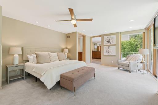 A fresh view of the restful main floor owner's suite with dual baths & private deck. Rest assured nature views are here. The separate doors at the far side of this image are for the separate owner's baths, each with special features!