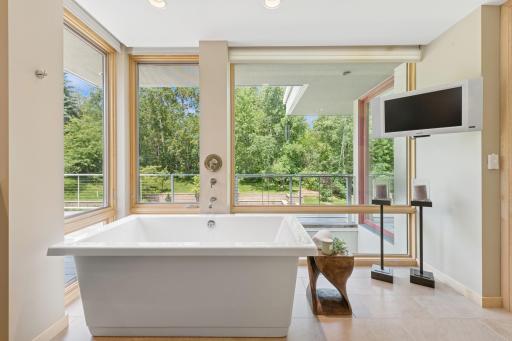 First of 2 owner's baths, with a tub in addition to its own custom shower. The 2nd owner's bath also has a custom shower. Both owner's baths have private sink & commode spaces & custom chest of drawers. Plus, separate walk-in closets for each.