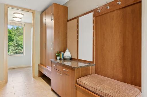Mud room with double access. Built-in seat & easy space for shoe storage. A pocket door beyond the cabinets brings bonus storage. A window west & full view door east, deliver natural light.