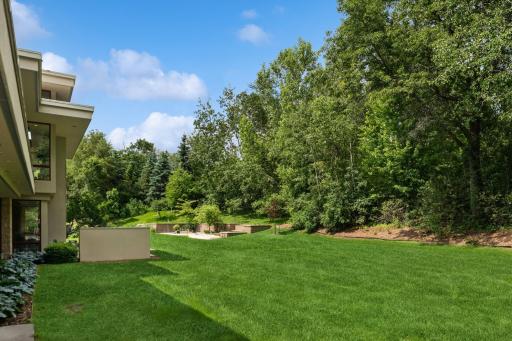 The backyard as seen from your sport court. An outdoor kitchen is on the left & in the distance the fire pit area. Beyond that, your raised gardens.