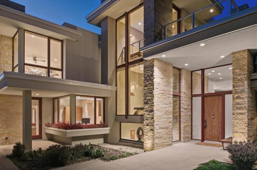 Twilight comes with dramatic lighting of front entrances... just left of the flower boxes the casual entrance. The grand entrance is flanked by tall columns of hand-chiseled stone. Both entrances provide shelter from precipitation, welcome friends!
