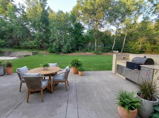 2nd patio & 2nd kitchen with space for another table or lounge off camera left. Huge playful yard & your fire pit is across the lawn. Ample trees & privacy are at home in this acreage setting. Virtual staged.