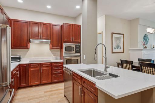 An abundance of cherry cabinets, recessed lights and a newly revamped "island" has a deep single basin sink, faucet, new dishwasher and quartz top!