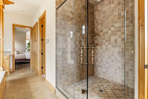The full bathroom includes a large tile shower with glass door