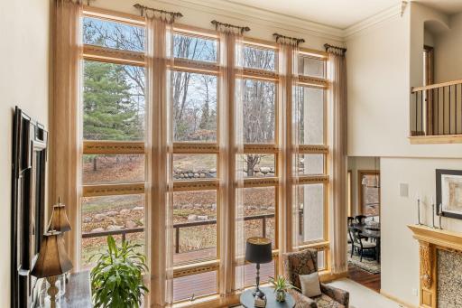 Floor to ceiling windows frame the back wall of the living room showcasing the private yard.