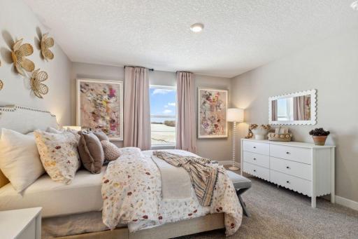 Each of the home's three secondary upper-level bedrooms are spacious, and each have immediate access to their own bath - two of which share a Jack and Jill! Photo of a model home, color & options will vary.