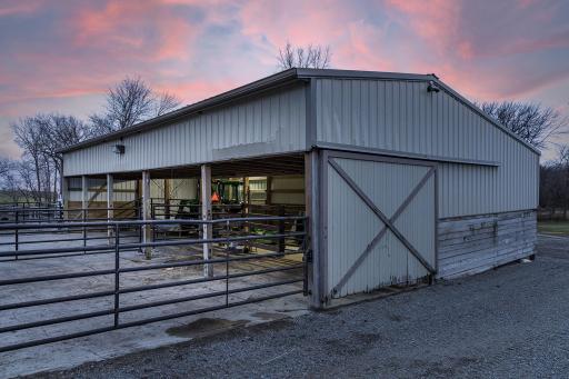 Cattle barn with front wall removed and rail fencing