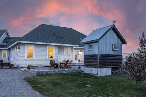 Back yard deck surrounding a built-in above-ground pool, stone patio, and outdoor sauna with mudroom entrance to laundry and a full bath, such a great set up!