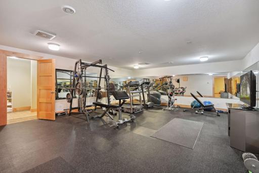 450+ sq ft home gym looks enormous with the wrap-around mirrors and features a built-in water fountain