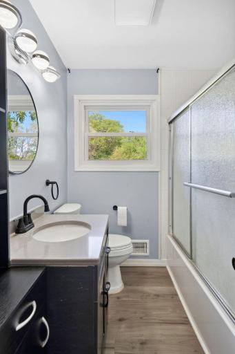 The bathroom has a new vanity and light fixtures, giving it a fresh, updated look.