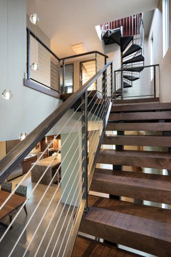Architectural staircase leading to second floor bedrooms and spiral staircase to rooftop terrace