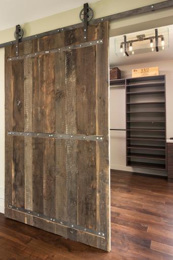 Primary bedroom walk in closet with barn door sourced from Utah