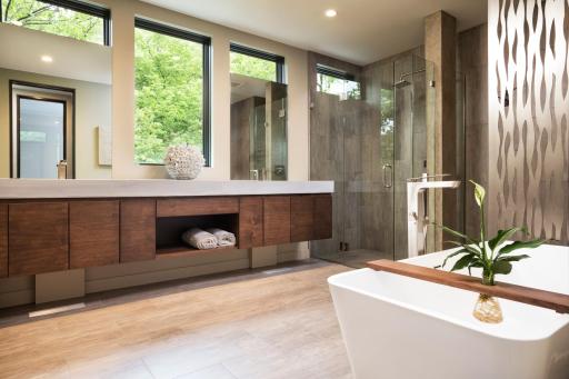 Spa-like primary bathroom has a ton of built in storage and heated floors