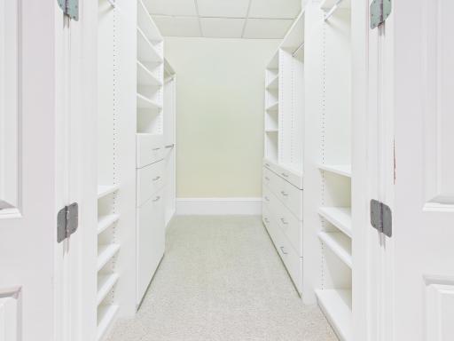 Spacious walk-in closet with custom cabinets
