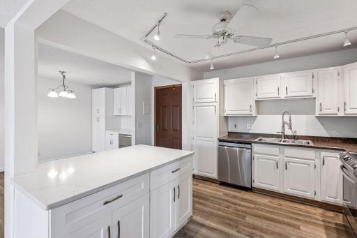 The gleaming white cabinets and counters create a spotless, bright kitchen!
