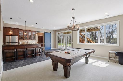 Lower Level with bar, guest bedroom, laundry and walkout to pool/backyard
