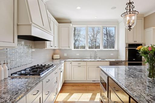 Kitchen with granite countertops and enameled cabinets with storage.