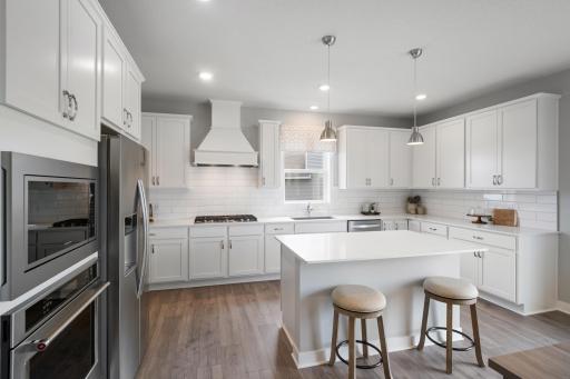 Welcome to the heart of the home. Well-appointed Gourmet kitchen with tile back splash, quartz countertops, walk-in pantry and more! *Photo of model home; same floor plan; colors and options may vary.