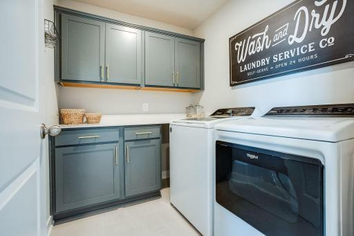 Upper level laundry room has built in cabinetry and countertop space. Conveniently located amongst bedrooms, with plenty of space for sorting and folding.