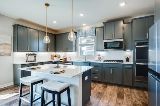 The center of the home, the kitchen! Large island, quartz countertops, subway tile backsplash, gas cooktop, double ovens, and huge walk-in pantry!