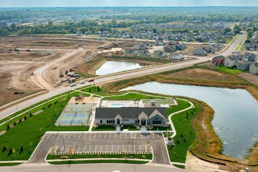 Aerial view of the clubhouse and outdoor amenities (pool, pickleball courts, basketball court, bocce ball, and playground!). Pond views from the clubhouse too!