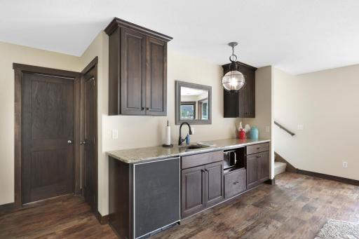 The intelligently designed lower level walks out to a massive paver patio and features a spacious family room with a wet bar, an easily accessible bathroom to serve the indoor and outdoor common areas, a huge storage room and a utility room.