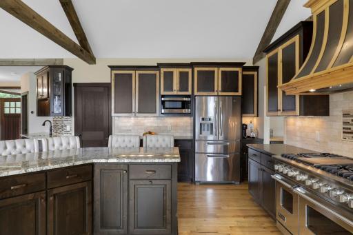 The chefâs kitchen, open to the dining and living rooms, features a Viking double oven with 6-burners + a griddle, custom fanhood which vents to the exterior, an oversized refrigerator, new dishwasher, pantry, a huge granite topped island & wet bar.