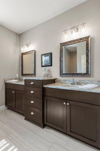 The primary ensuite bathroom includes a double sink with leathered marble countertops.