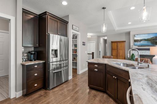 The kitchen features a gorgeous angled island, elegant leathered marble countertops and stainless steel appliances.