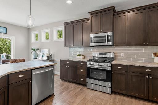 This kitchen features gorgeous stained cabinets and a subway tile backsplash.