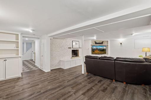 The lower level showcases a family room, charming bar, three-quarter bathroom, and hidden storage room concealed behind a sliding bookcase.