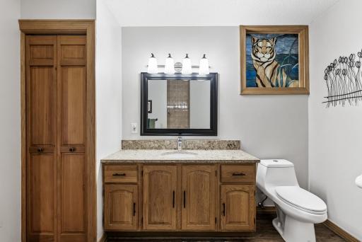 The lower-level bathroom includes built-in storage for effortless organization.