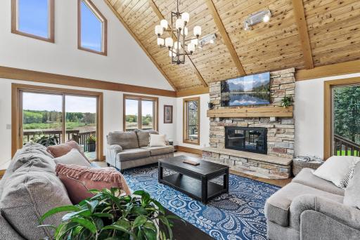 Vaulted wood-paneled ceilings and expansive south-facing windows bathe this open living space in natural light year-round.
