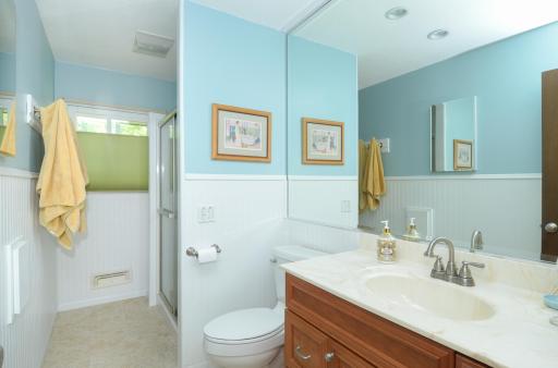 The bathroom is outfitted with a walk-in shower, gorgeous tile floors & loads of storage!