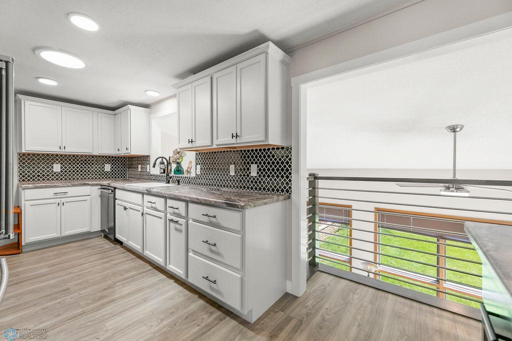 White cabinets, tile backsplash, recessed lighting
