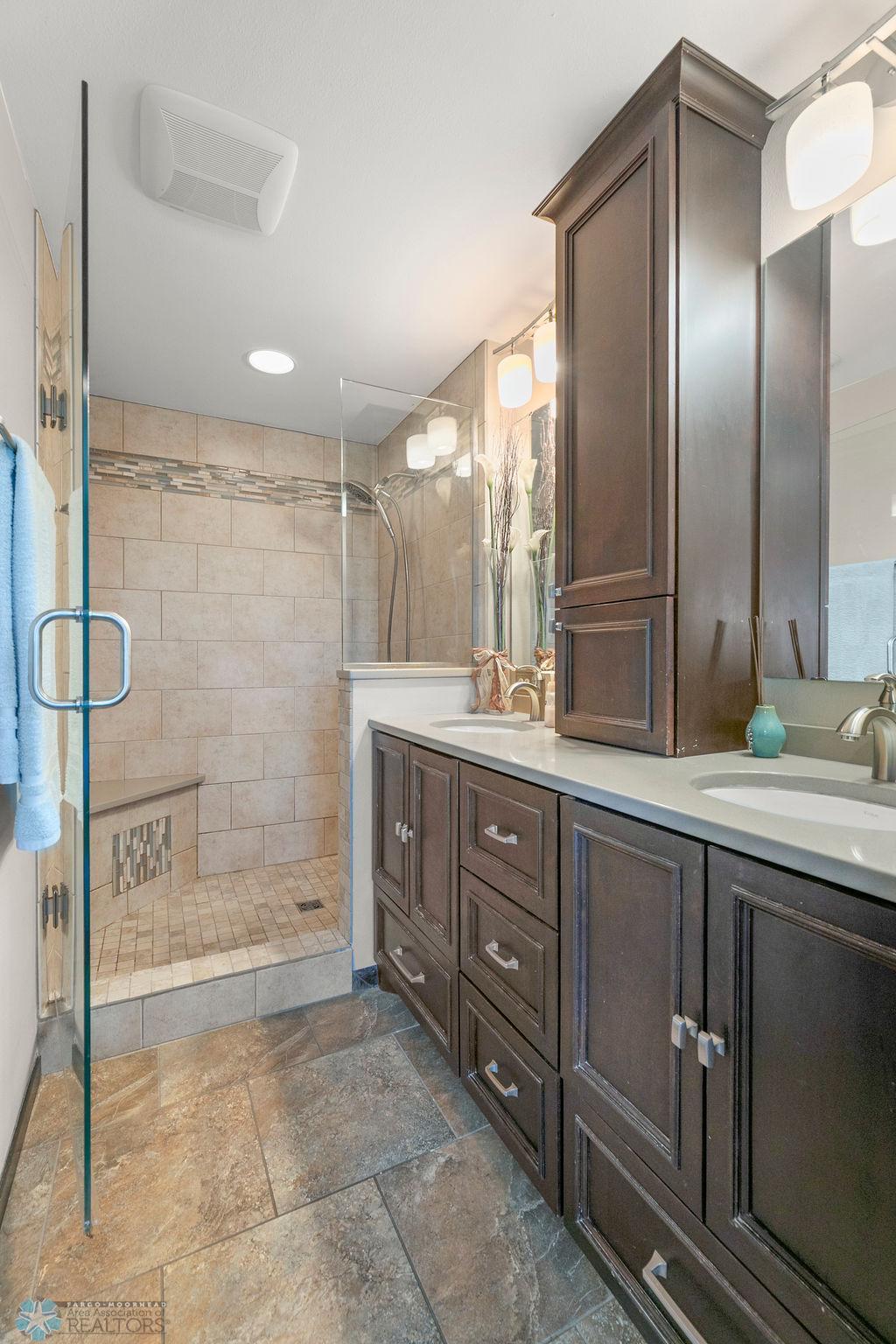 Tiled walk-in shower & double sinks in the Primary Bathroom