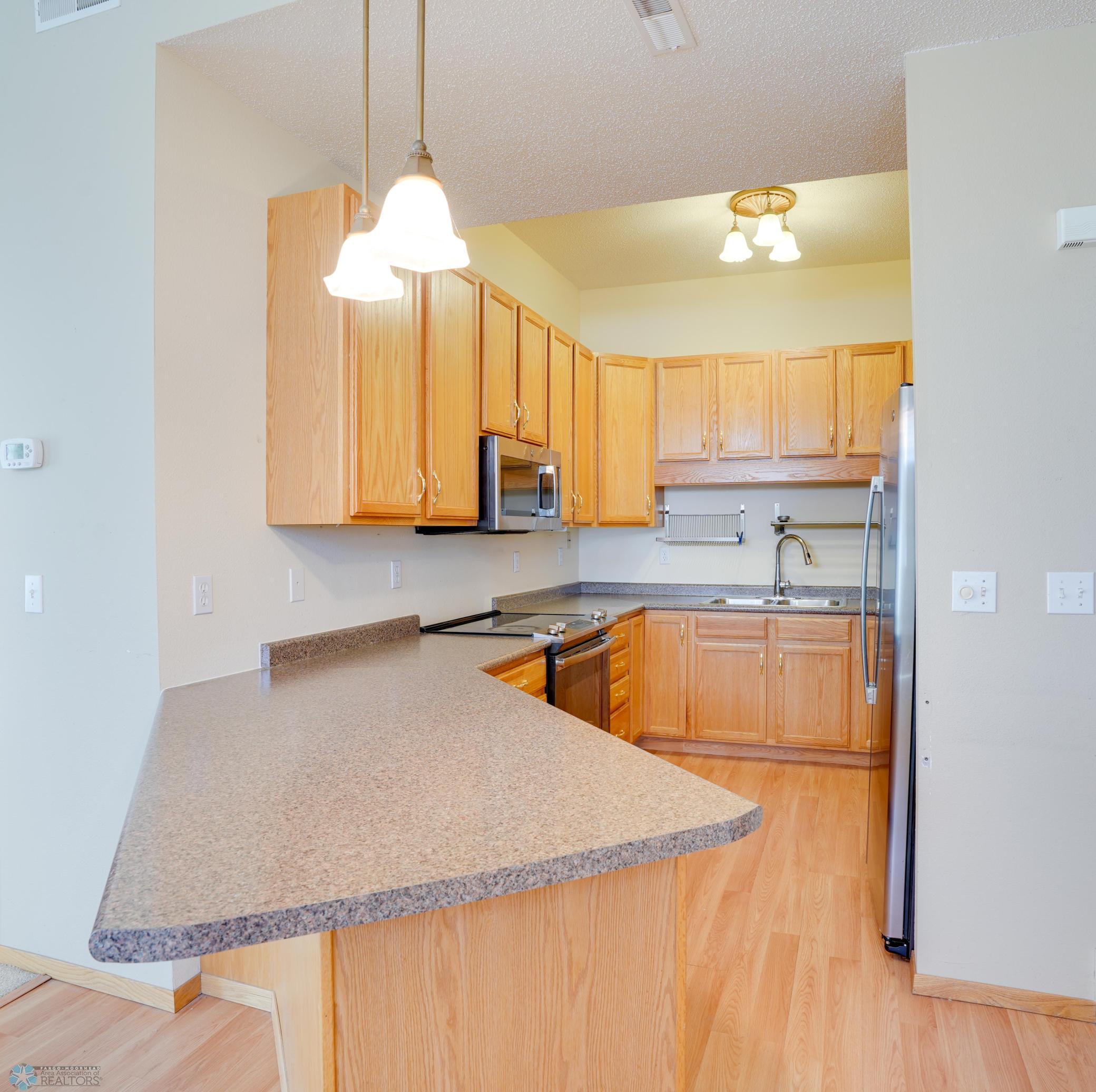 Kitchen has lots of cabinets & counterspace, S/S appliances, breakfast bar for seating