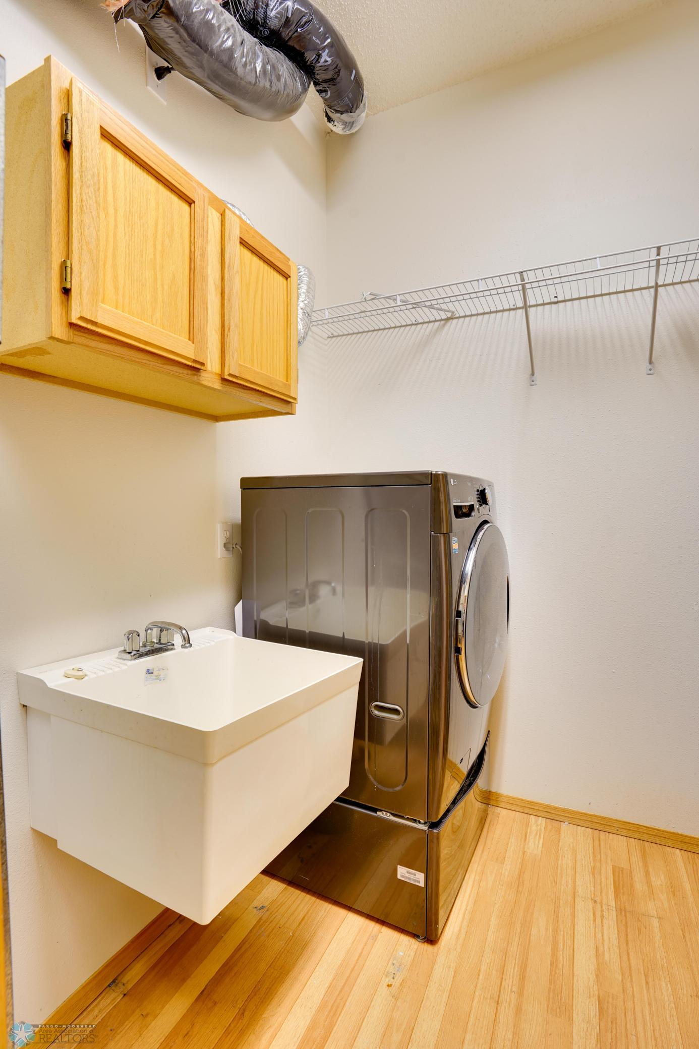 Laundry room with storage, utility sink & mechanicals