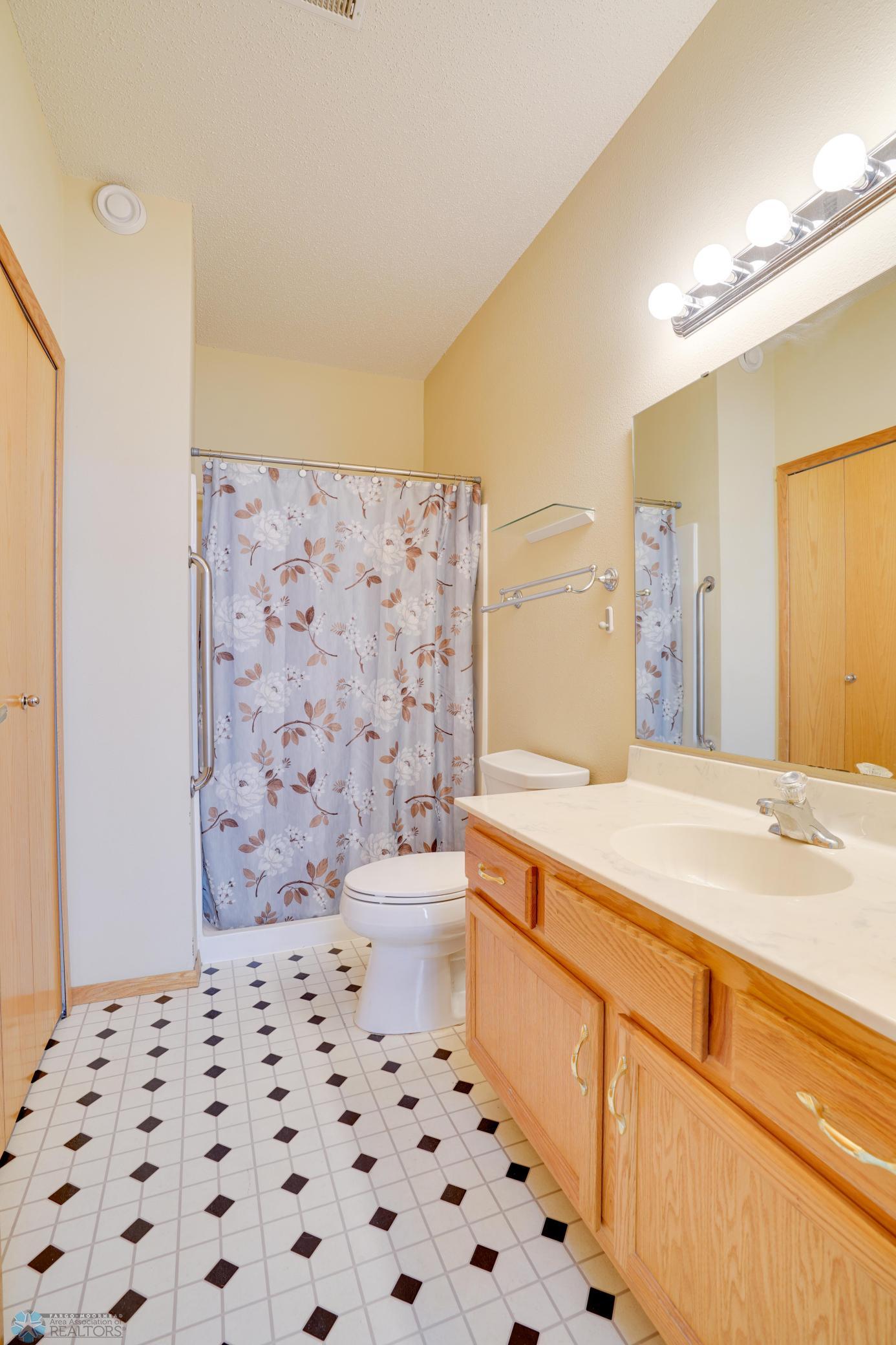 Private primary bathroom with spacious vanity, storage closet & walk-in shower