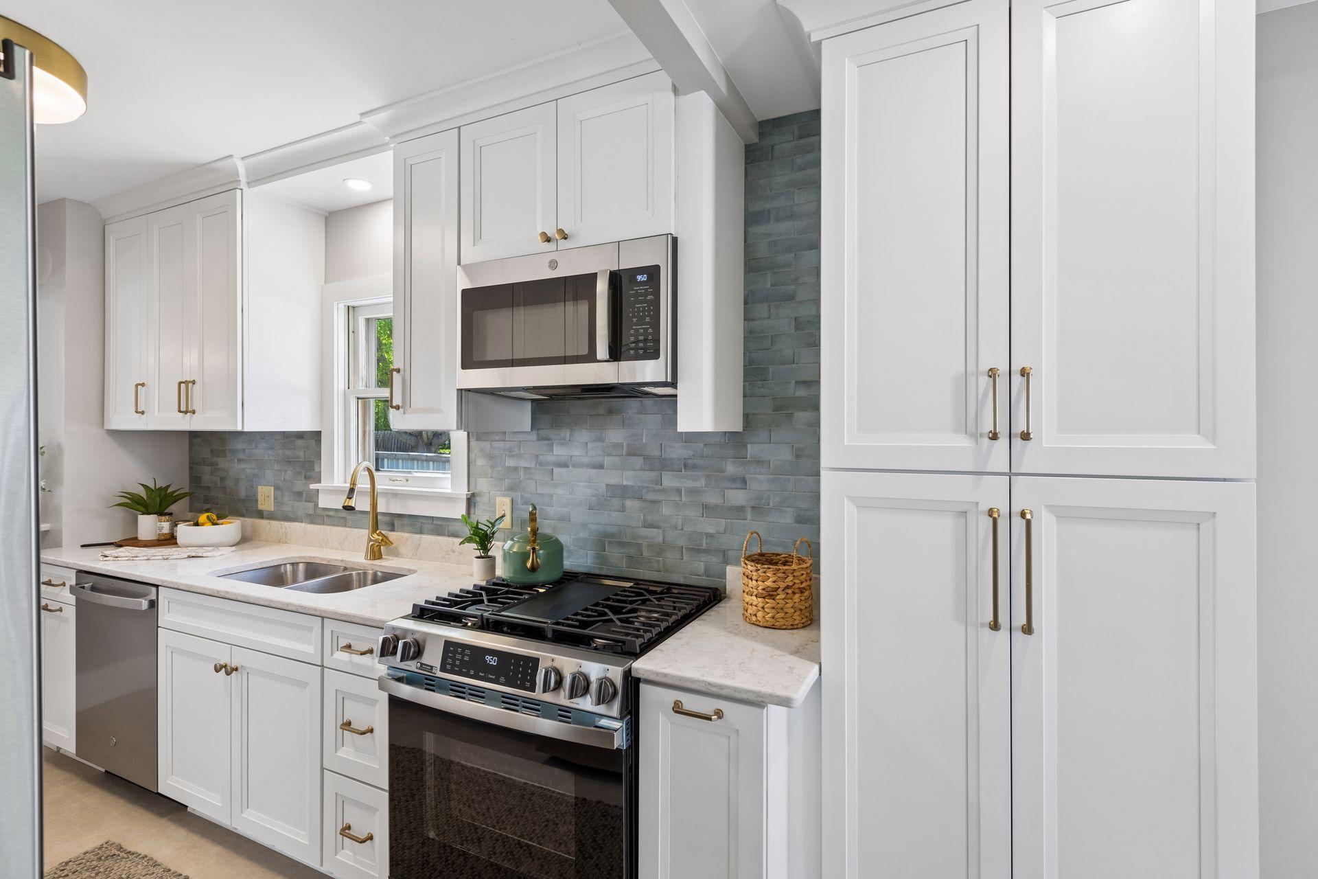 Tasteful tile backsplash and stylish brass handles, faucet and lighting make this shine with elegance.
