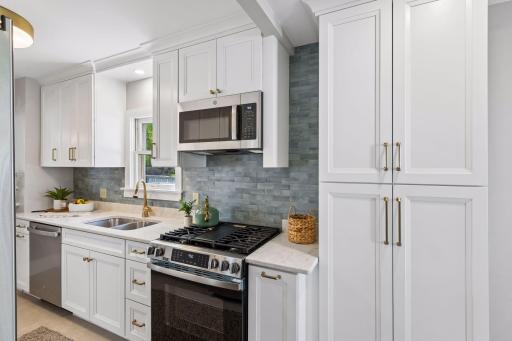 Tasteful tile backsplash and stylish brass handles, faucet and lighting make this shine with elegance.