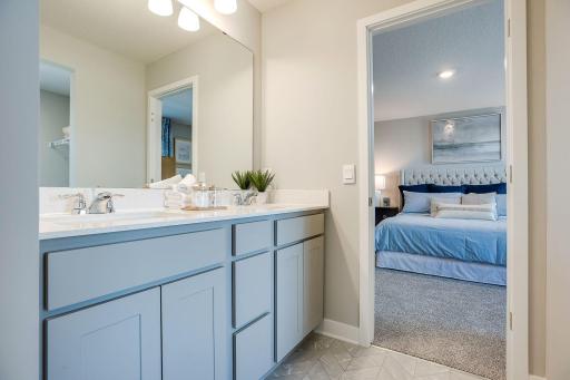 A peak into the primary bath, which features a Quartz coated double-vanity - making getting ready on those hectic mornings that much easier - and oversized stand-in shower! (Photo of model, colors may vary)