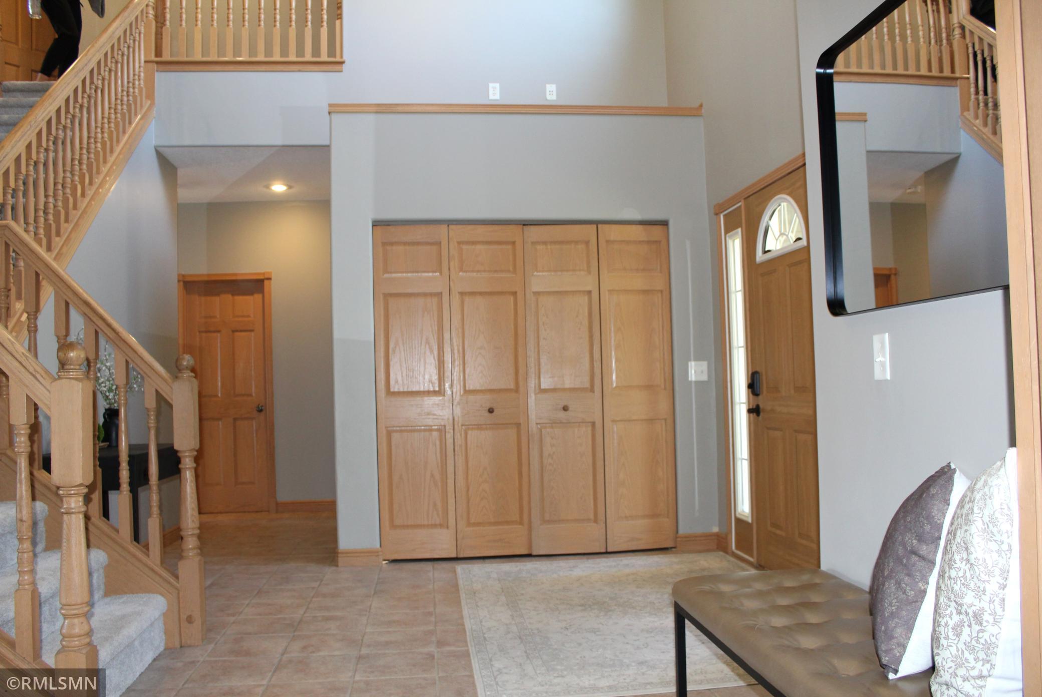 The foyer is open and spacious with two story ceilings and a large closet for homeowners and/or guests