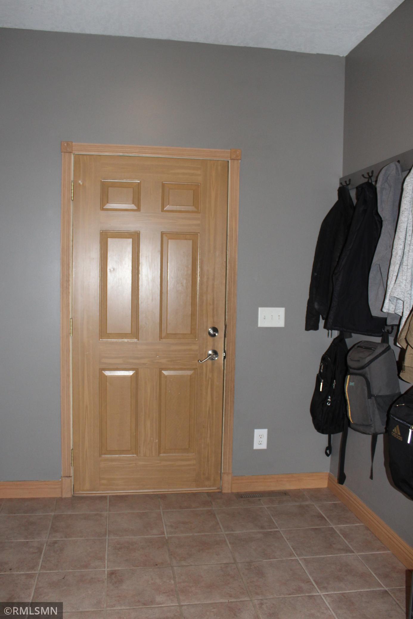 The mudroom entrance off the garage has hooks for coats and backpacks as well as a closet with built-in storage
