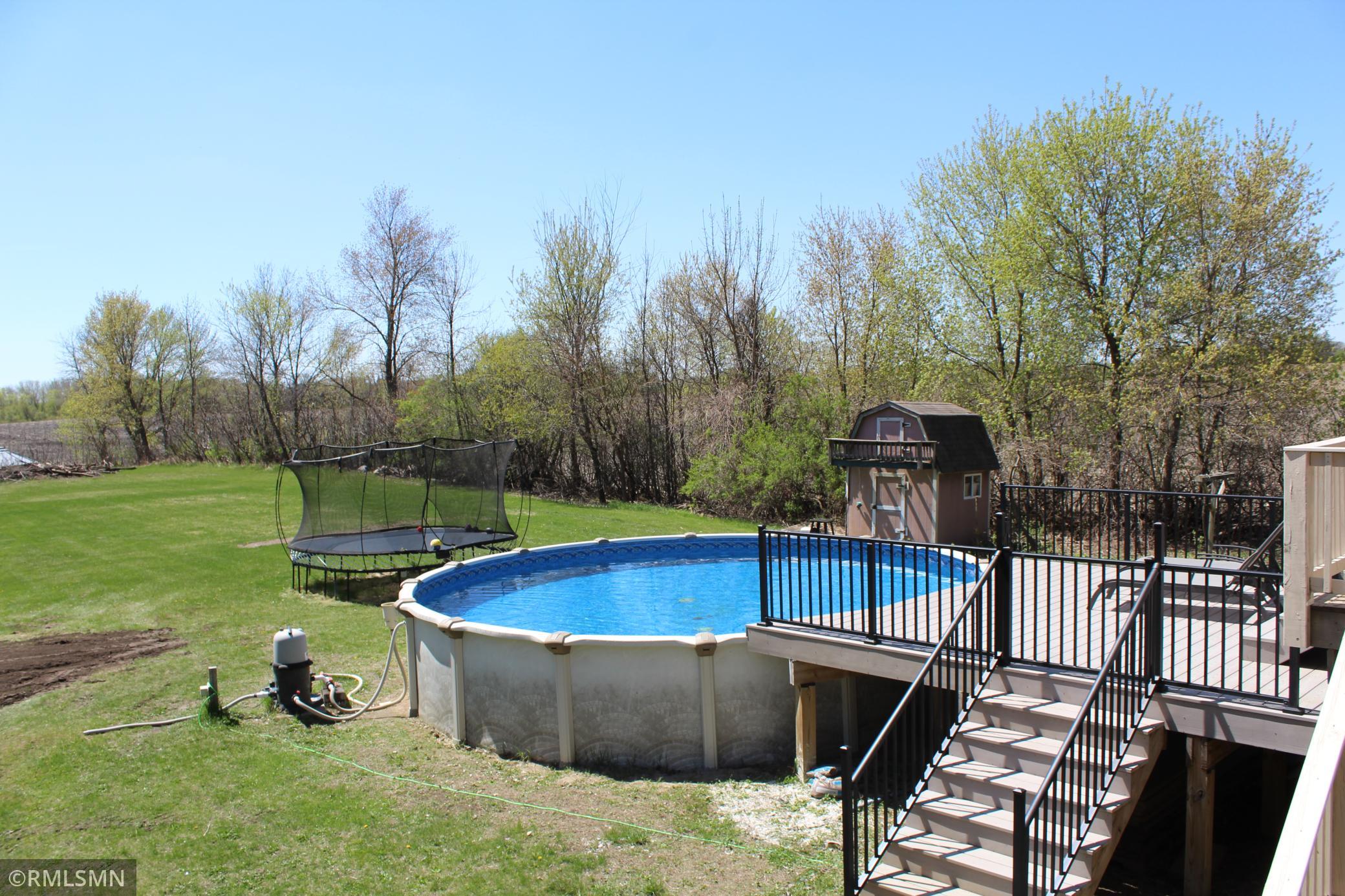 The back porch and deck step down to a maintenance-free pool deck in the back yard