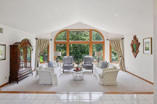 The floor to ceiling window frames the outside like a piece of art for this formal living room space