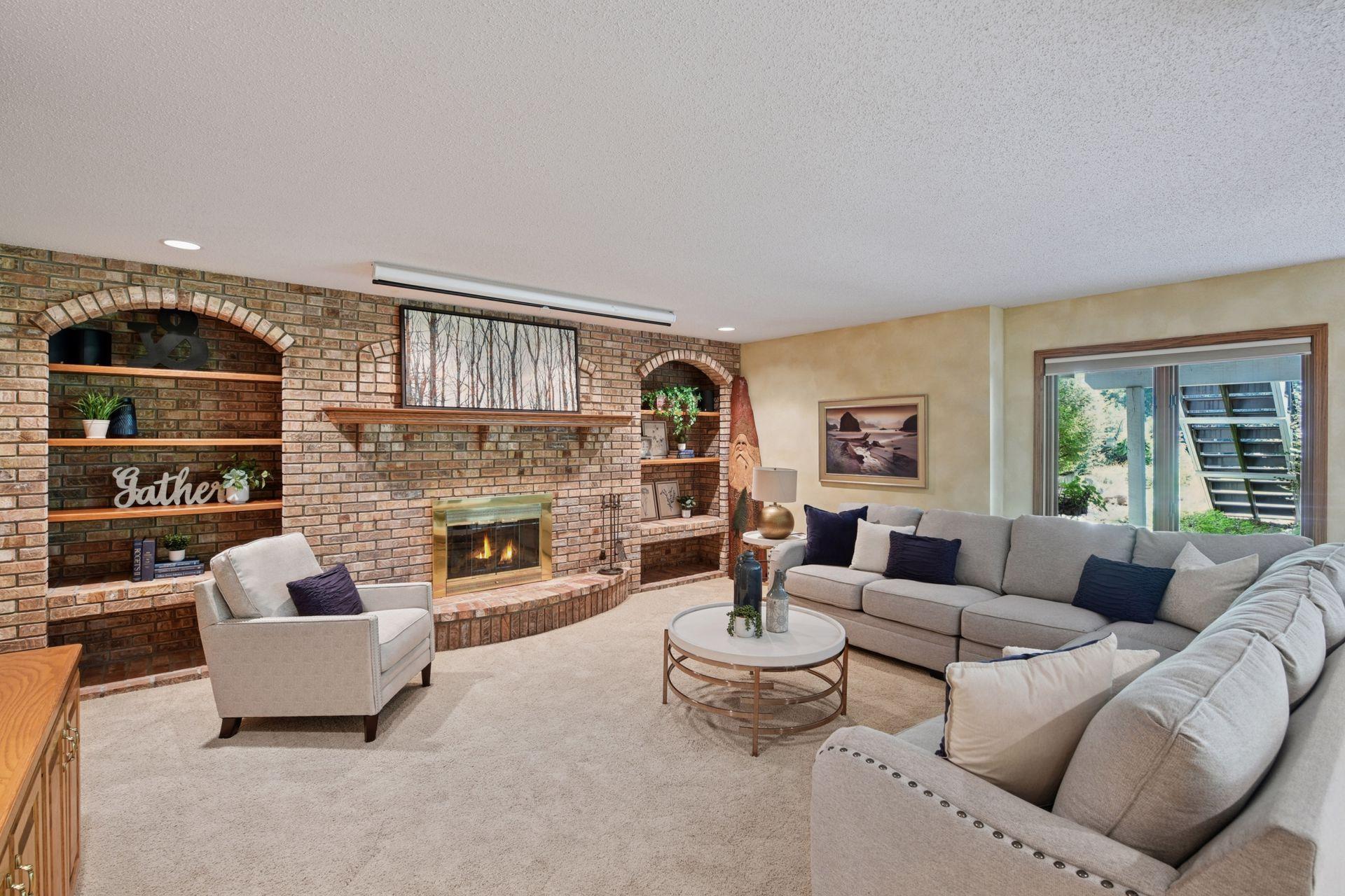 Brick accents, shelving, and wood burning fireplace give this space an inviting atmosphere