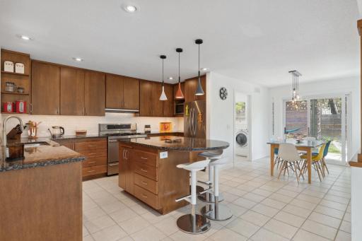 The kitchen and island flow seamlessly into the informal dining area, which opens to an expansive deckâperfect for hosting gatherings