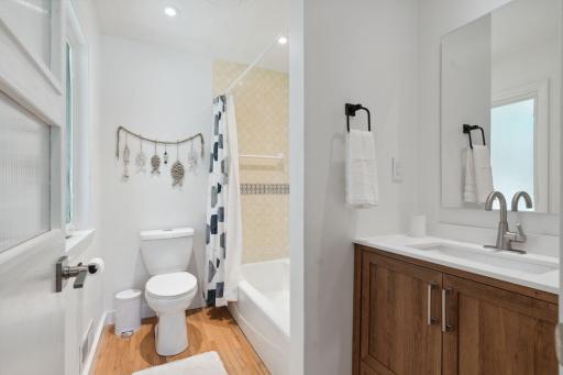 Charming en-suite bathroom with updated vanity, featuring unique finishes and full of character.