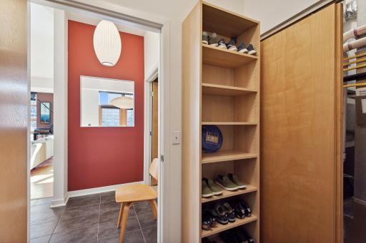 Entryway has large coat room closet with accessible HVAC/hot water mechanicals behind sliding wood doors.